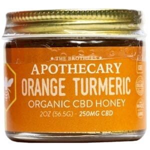 Orange Turmeric CBD Honey jar with citrus and turmeric flavor highlights